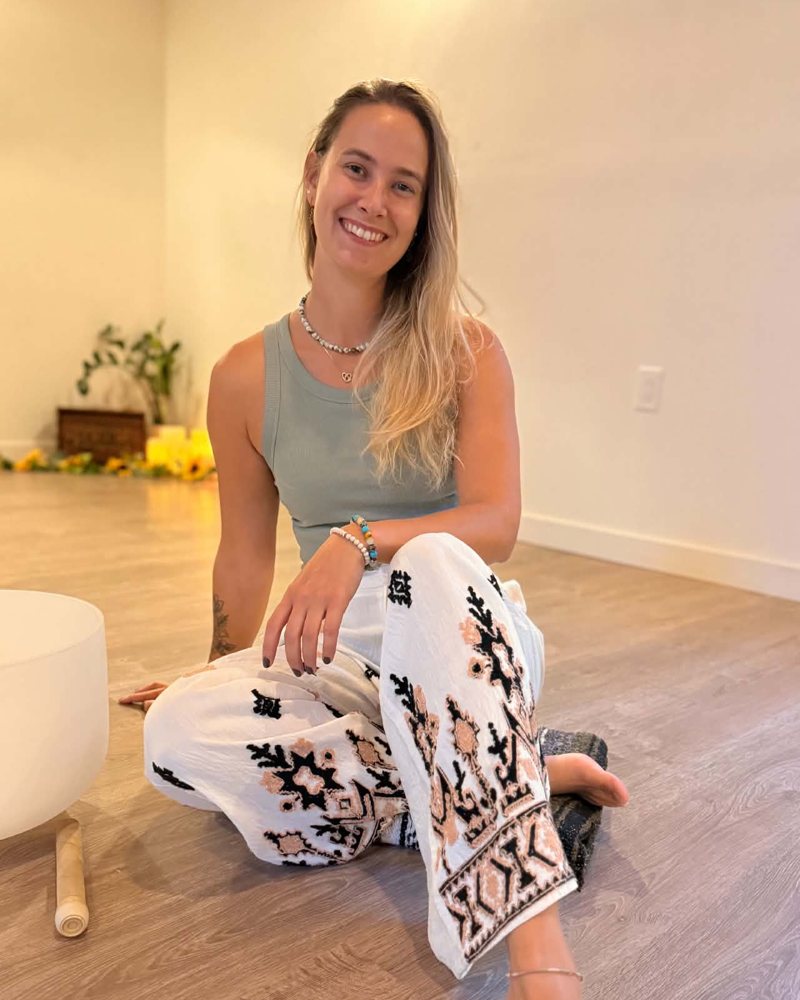 Bianca, souriante, assise au sol dans sa salle